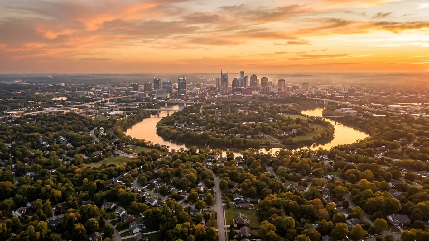Retaining wall contractor service areas | Nashville and Middle Tennessee A golden sunset aerial view of the Nashville skyline above tree-covered suburban neighborhoods with a winding river